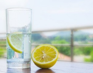 Glass of water with lemon isolated on white background