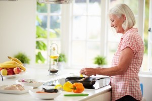 Middle Aged Woman Cooking Meal In Kitchen