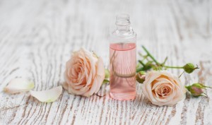 Bottle of essential oil and pink roses