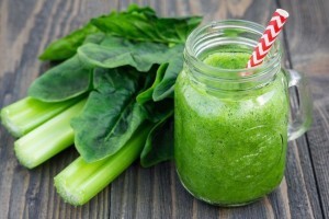 Green smoothie with celery, cucumber, spinach, apple, lemon in glass