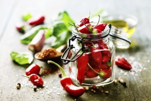 Red Hot Chili Peppers with herbs and spices over wooden background - cooking or spicy food concept