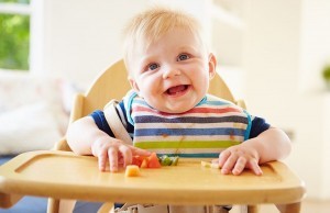 child-in-high-chair-eating-fruit