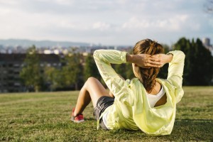 Woman doing situps and exercising in city park